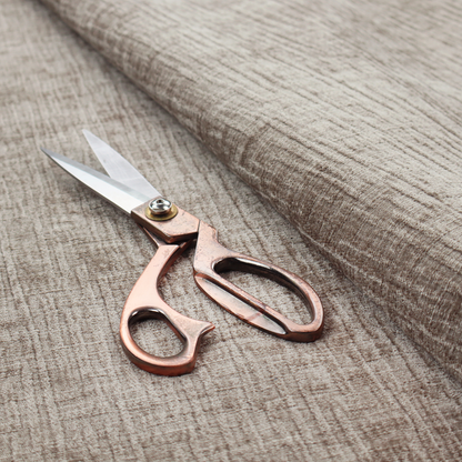 A textured upholstery fabric in a neutral taupe or greige colour. The material features a distinctive cross-hatched slub texture with subtle vertical and horizontal ridges, creating a soft, dimensional chenille finish.