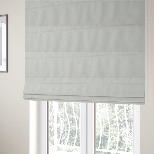 The fabric used to create these Roman blinds is a textured upholstery fabric in a clean white or light ivory colour. The material features a subtle cross-hatched slub texture with fine vertical and horizontal ridges, creating a soft, dimensional chenille finish.