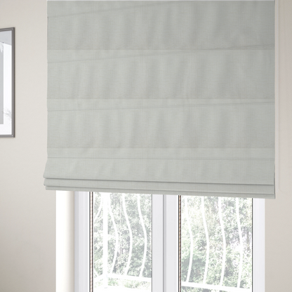 The fabric used to create these Roman blinds is a textured upholstery fabric in a clean white or light ivory colour. The material features a subtle cross-hatched slub texture with fine vertical and horizontal ridges, creating a soft, dimensional chenille finish.