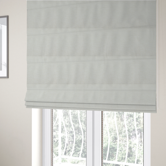 The fabric used to create these Roman blinds is a textured upholstery fabric in a clean white or light ivory colour. The material features a subtle cross-hatched slub texture with fine vertical and horizontal ridges, creating a soft, dimensional chenille finish.