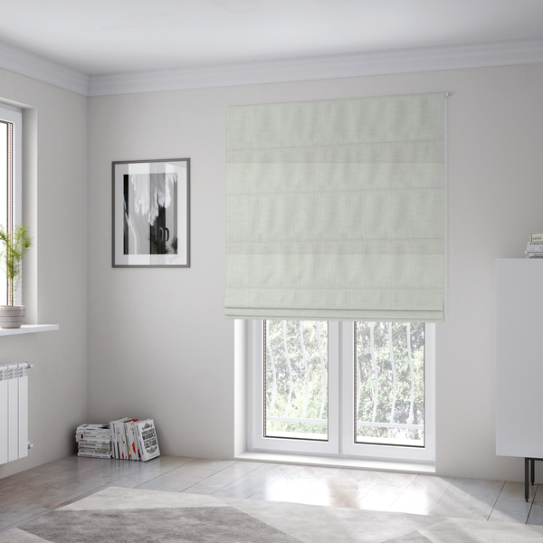 The fabric used to create these Roman blinds is a textured upholstery fabric in a clean white or light ivory colour. The material features a subtle cross-hatched slub texture with fine vertical and horizontal ridges, creating a soft, dimensional chenille finish.