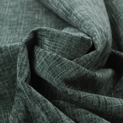 A textured upholstery fabric in a deep teal or eucalyptus green colour. The material features a distinct cross-hatched slub texture with subtle vertical and horizontal ridges, creating a soft, dimensional chenille finish.