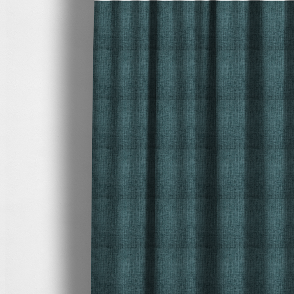 The fabric used to create these made-to-measure curtains is a textured upholstery fabric in a vibrant peacock blue or deep teal shade. The material features a distinct cross-hatched slub texture with prominent vertical and fine horizontal ridges, creating a soft, dimensional chenille finish.