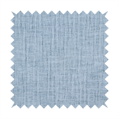 A textured upholstery fabric in a soft powder blue or light sky blue shade. The material features a distinct cross-hatched slub texture with subtle vertical and horizontal ridges, creating a soft, dimensional chenille finish.