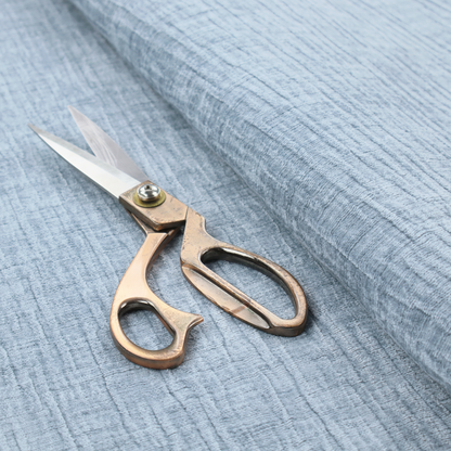 A textured upholstery fabric in a soft powder blue or light sky blue shade. The material features a distinct cross-hatched slub texture with subtle vertical and horizontal ridges, creating a soft, dimensional chenille finish.