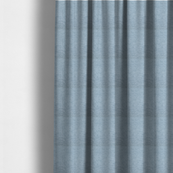 The fabric used to create these made-to-measure curtains is a textured upholstery fabric in a soft powder blue or light sky blue shade. The material features a distinct cross-hatched slub texture with subtle vertical and horizontal ridges, creating a soft, dimensional chenille finish.
