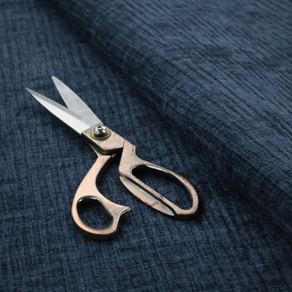 A textured upholstery fabric in a deep navy or midnight blue shade. The material features a distinct cross-hatched slub texture with prominent vertical and fine horizontal ridges, creating a soft, dimensional chenille finish.