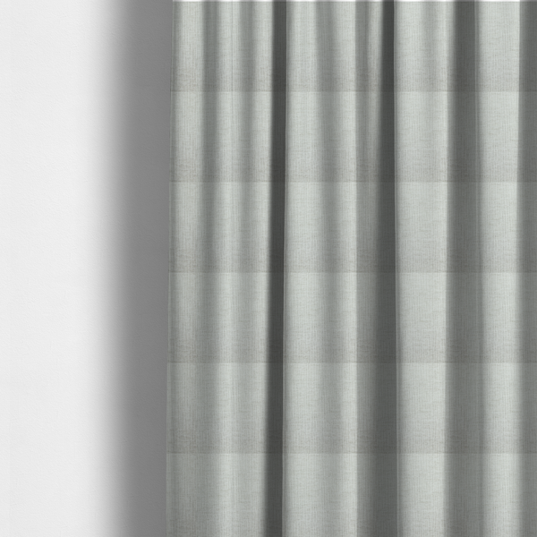 The fabric used to create these made-to-measure curtains is a textured upholstery fabric in a light silver or pale grey colour. The material features a subtle cross-hatched slub texture with fine vertical and horizontal ridges, creating a soft, dimensional chenille finish.