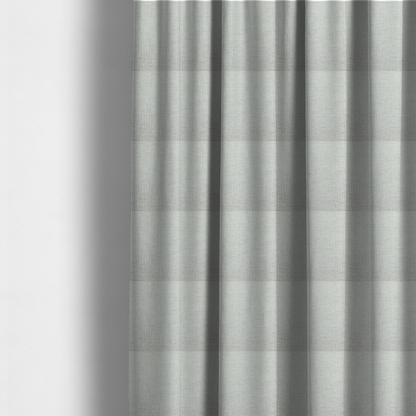 The fabric used to create these made-to-measure curtains is a textured upholstery fabric in a light silver or pale grey colour. The material features a subtle cross-hatched slub texture with fine vertical and horizontal ridges, creating a soft, dimensional chenille finish.