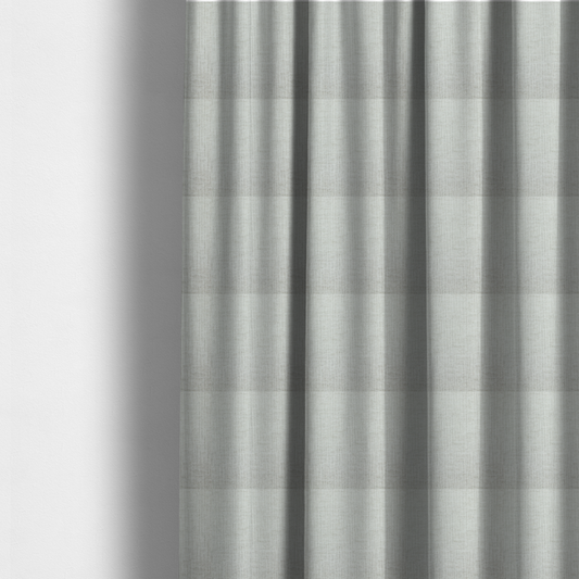The fabric used to create these made-to-measure curtains is a textured upholstery fabric in a light silver or pale grey colour. The material features a subtle cross-hatched slub texture with fine vertical and horizontal ridges, creating a soft, dimensional chenille finish.