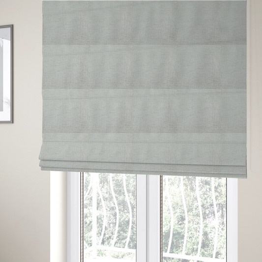 The fabric used to create these Roman blinds is a textured upholstery fabric in a light silver or pale grey colour. The material features a subtle cross-hatched slub texture with fine vertical and horizontal ridges, creating a soft, dimensional chenille finish.