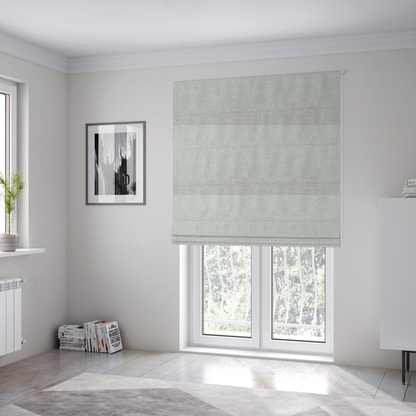 The fabric used to create these Roman blinds is a textured upholstery fabric in a light silver or pale grey colour. The material features a subtle cross-hatched slub texture with fine vertical and horizontal ridges, creating a soft, dimensional chenille finish.