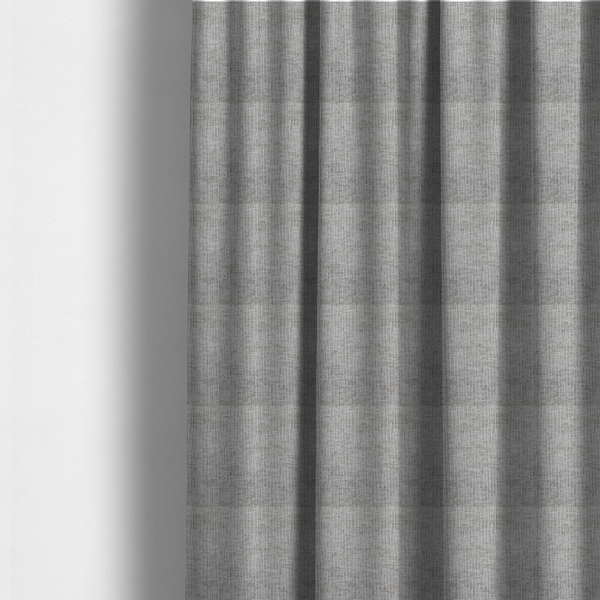 The fabric used to create these made-to-measure curtains is a textured upholstery fabric in a mid-tone grey or pebble shade. The material features a distinct cross-hatched slub texture with prominent vertical and fine horizontal ridges, creating a soft, dimensional chenille finish.