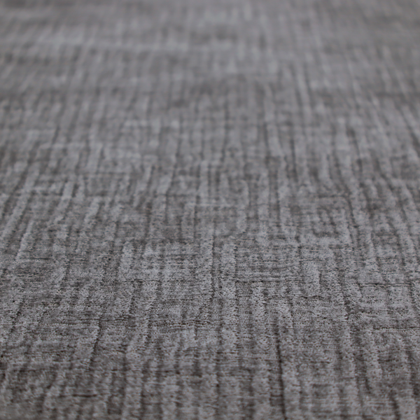 A textured upholstery fabric in a charcoal or dark grey shade. The material features a distinct cross-hatched slub texture with subtle vertical and horizontal ridges, creating a soft, dimensional chenille finish.