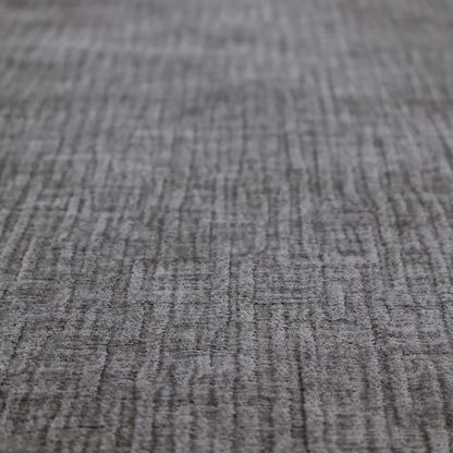 A textured upholstery fabric in a charcoal or dark grey shade. The material features a distinct cross-hatched slub texture with subtle vertical and horizontal ridges, creating a soft, dimensional chenille finish.