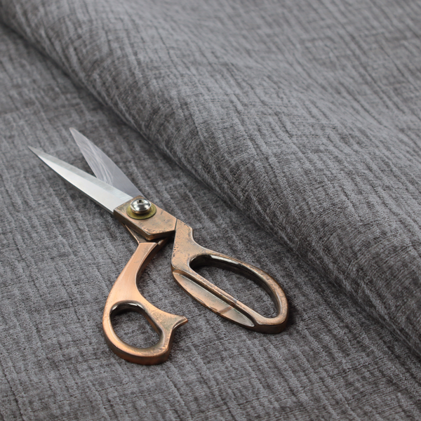 A textured upholstery fabric in a charcoal or dark grey shade. The material features a distinct cross-hatched slub texture with subtle vertical and horizontal ridges, creating a soft, dimensional chenille finish.