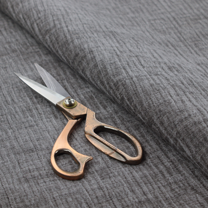 A textured upholstery fabric in a charcoal or dark grey shade. The material features a distinct cross-hatched slub texture with subtle vertical and horizontal ridges, creating a soft, dimensional chenille finish.