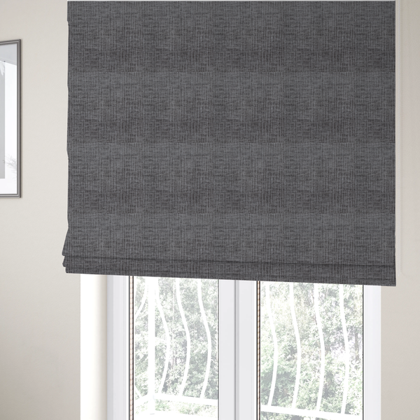 The fabric used to create these Roman blinds textured upholstery fabric in a charcoal or dark grey shade. The material features a distinct cross-hatched slub texture with subtle vertical and horizontal ridges, creating a soft, dimensional chenille finish.