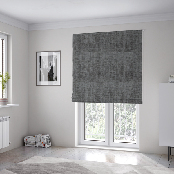 The fabric used to create these Roman blinds textured upholstery fabric in a charcoal or dark grey shade. The material features a distinct cross-hatched slub texture with subtle vertical and horizontal ridges, creating a soft, dimensional chenille finish.