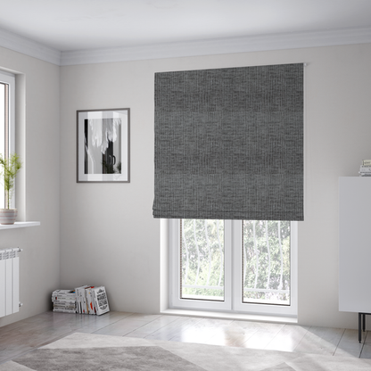 The fabric used to create these Roman blinds textured upholstery fabric in a charcoal or dark grey shade. The material features a distinct cross-hatched slub texture with subtle vertical and horizontal ridges, creating a soft, dimensional chenille finish.