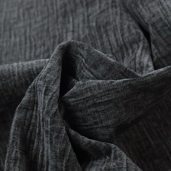A textured upholstery fabric in a near-black or dark anthracite shade. The material features a distinct cross-hatched slub texture with prominent vertical and fine horizontal ridges, creating a soft, dimensional chenille finish.