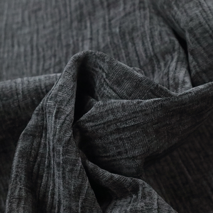 A textured upholstery fabric in a near-black or dark anthracite shade. The material features a distinct cross-hatched slub texture with prominent vertical and fine horizontal ridges, creating a soft, dimensional chenille finish.