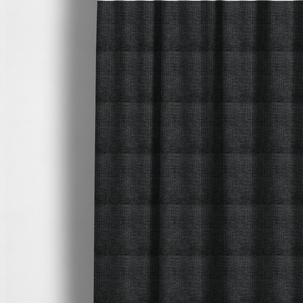 The fabric used to create these made-to-measure curtains is a textured upholstery fabric in a near-black or dark anthracite shade. The material features a distinct cross-hatched slub texture with prominent vertical and fine horizontal ridges, creating a soft, dimensional chenille finish.