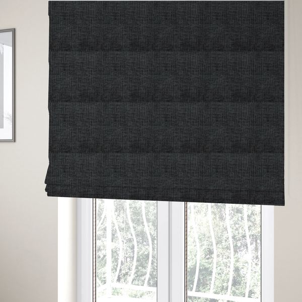 The fabric used to create these Roman blinds is a textured upholstery fabric in a near-black or dark anthracite shade. The material features a distinct cross-hatched slub texture with prominent vertical and fine horizontal ridges, creating a soft, dimensional chenille finish.