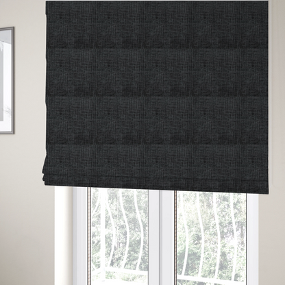 The fabric used to create these Roman blinds is a textured upholstery fabric in a near-black or dark anthracite shade. The material features a distinct cross-hatched slub texture with prominent vertical and fine horizontal ridges, creating a soft, dimensional chenille finish.