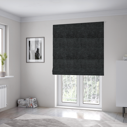 The fabric used to create these Roman blinds is a textured upholstery fabric in a near-black or dark anthracite shade. The material features a distinct cross-hatched slub texture with prominent vertical and fine horizontal ridges, creating a soft, dimensional chenille finish.