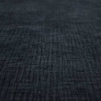 A textured upholstery fabric in a deep midnight black or very dark charcoal shade. The material features a distinct cross-hatched slub texture with subtle vertical and horizontal ridges, creating a soft, dimensional chenille finish.