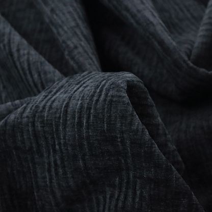 A textured upholstery fabric in a deep midnight black or very dark charcoal shade. The material features a distinct cross-hatched slub texture with subtle vertical and horizontal ridges, creating a soft, dimensional chenille finish.