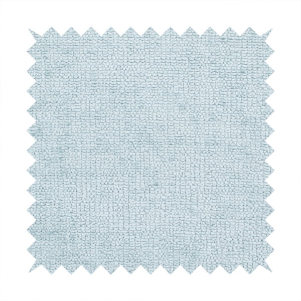 A textured fabric swatch in a soft, pale ice-blue colour. The material features a dense, uniform nubby weave or loop texture, resembling chenille, bouclé, or terry cloth, with subtle variations in shading that create a matte, soft appearance.