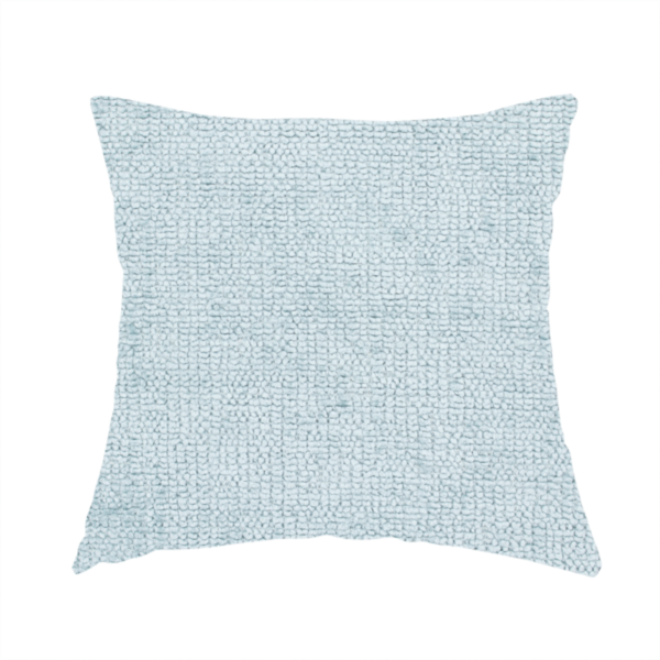 The fabric used to create these handmade cushions is a textured fabric swatch in a soft, pale ice-blue colour. The material features a dense, uniform nubby weave or loop texture, resembling chenille, bouclé, or terry cloth, with subtle variations in shading that create a matte, soft appearance.