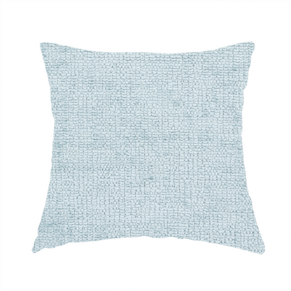 The fabric used to create these handmade cushions is a textured fabric swatch in a soft, pale ice-blue colour. The material features a dense, uniform nubby weave or loop texture, resembling chenille, bouclé, or terry cloth, with subtle variations in shading that create a matte, soft appearance.