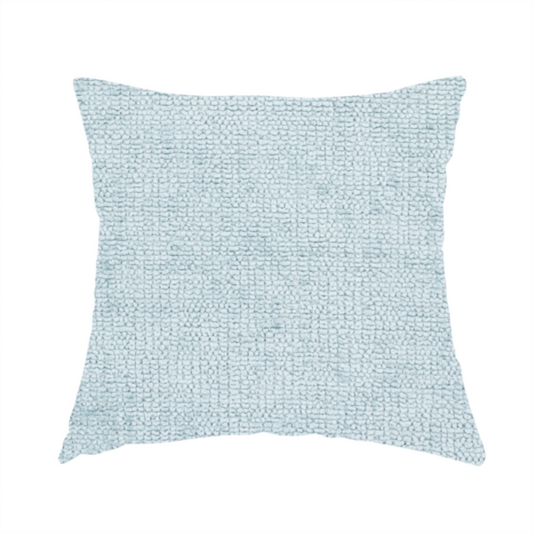 The fabric used to create these handmade cushions is a textured fabric swatch in a soft, pale ice-blue colour. The material features a dense, uniform nubby weave or loop texture, resembling chenille, bouclé, or terry cloth, with subtle variations in shading that create a matte, soft appearance.
