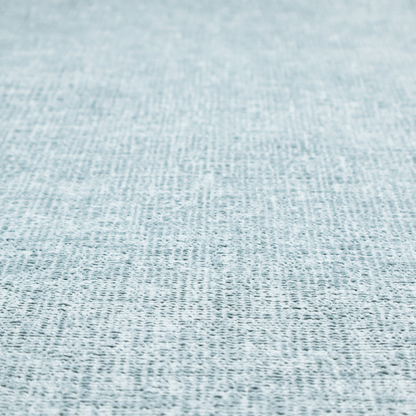 A textured fabric swatch in a soft, pale ice-blue colour. The material features a dense, uniform nubby weave or loop texture, resembling chenille, bouclé, or terry cloth, with subtle variations in shading that create a matte, soft appearance.