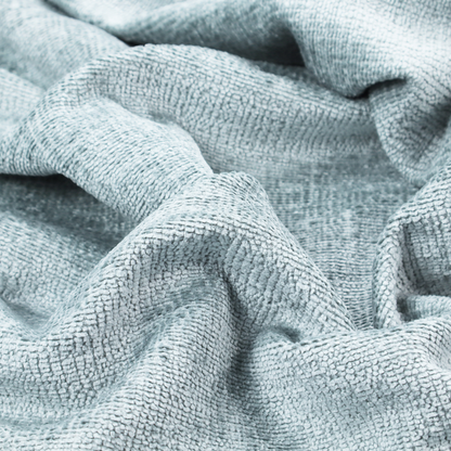 A textured fabric swatch in a soft, pale ice-blue colour. The material features a dense, uniform nubby weave or loop texture, resembling chenille, bouclé, or terry cloth, with subtle variations in shading that create a matte, soft appearance.