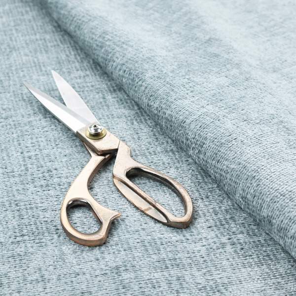 A textured fabric swatch in a soft, pale ice-blue colour. The material features a dense, uniform nubby weave or loop texture, resembling chenille, bouclé, or terry cloth, with subtle variations in shading that create a matte, soft appearance.