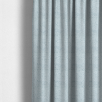 The fabric used to create these made-to-measure curtains is a textured fabric swatch in a soft, pale ice-blue colour. The material features a dense, uniform nubby weave or loop texture, resembling chenille, bouclé, or terry cloth, with subtle variations in shading that create a matte, soft appearance.