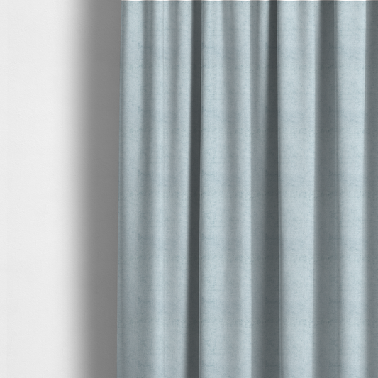 The fabric used to create these made-to-measure curtains is a textured fabric swatch in a soft, pale ice-blue colour. The material features a dense, uniform nubby weave or loop texture, resembling chenille, bouclé, or terry cloth, with subtle variations in shading that create a matte, soft appearance.