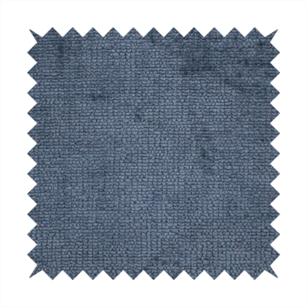 A textured fabric swatch in a deep slate blue or denim colour. The material features a dense, uniform nubby weave with subtle dark mottling throughout, giving the soft, textured surface a multi-tonal appearance.