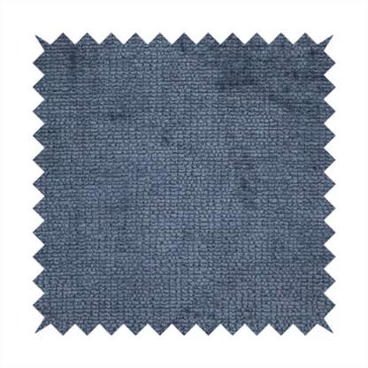 A textured fabric swatch in a deep slate blue or denim colour. The material features a dense, uniform nubby weave with subtle dark mottling throughout, giving the soft, textured surface a multi-tonal appearance.