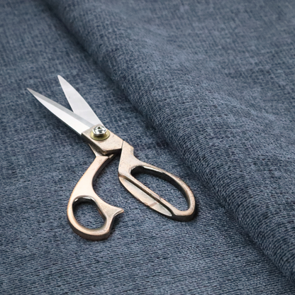 A textured fabric swatch in a deep slate blue or denim colour. The material features a dense, uniform nubby weave with subtle dark mottling throughout, giving the soft, textured surface a multi-tonal appearance.