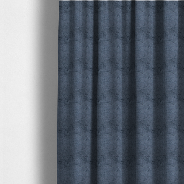 The fabric used to create these made-to-measure curtains is a textured fabric swatch in a deep slate blue or denim colour. The material features a dense, uniform nubby weave with subtle dark mottling throughout, giving the soft, textured surface a multi-tonal appearance.