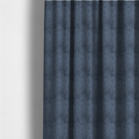 The fabric used to create these made-to-measure curtains is a textured fabric swatch in a deep slate blue or denim colour. The material features a dense, uniform nubby weave with subtle dark mottling throughout, giving the soft, textured surface a multi-tonal appearance.