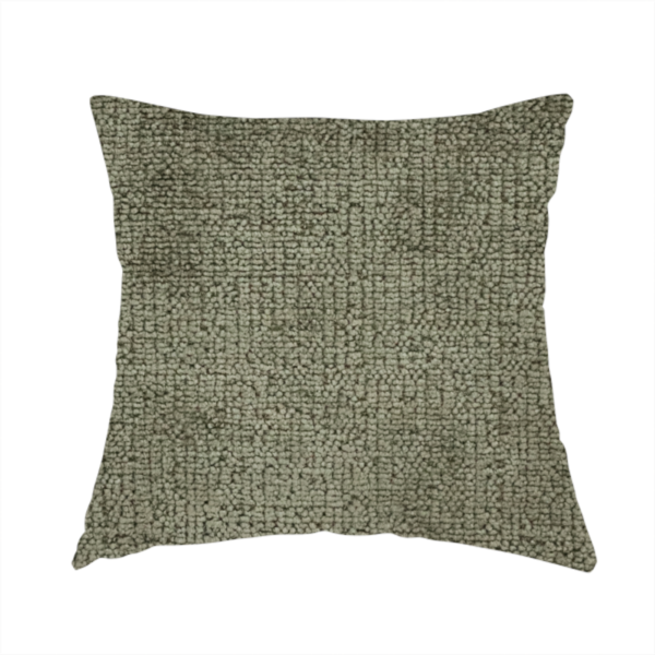 The fabric used to create this handmade cushion is a textured fabric swatch in an earthy olive green or sage colour. The material features a dense, uniform nubby weave with subtle dark mottling throughout, giving the soft, textured surface a multi-tonal, organic appearance.