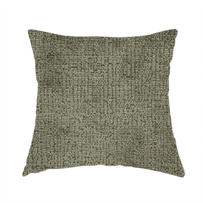 The fabric used to create this handmade cushion is a textured fabric swatch in an earthy olive green or sage colour. The material features a dense, uniform nubby weave with subtle dark mottling throughout, giving the soft, textured surface a multi-tonal, organic appearance.