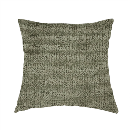 The fabric used to create this handmade cushion is a textured fabric swatch in an earthy olive green or sage colour. The material features a dense, uniform nubby weave with subtle dark mottling throughout, giving the soft, textured surface a multi-tonal, organic appearance.