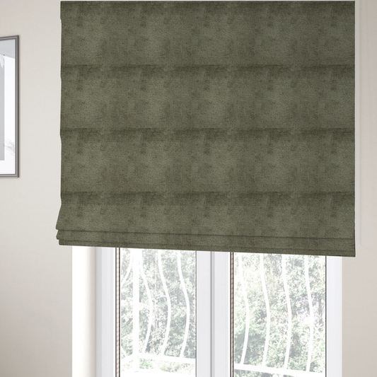 The fabric used to create these Roman blinds is a textured fabric swatch in an earthy olive green or sage colour. The material features a dense, uniform nubby weave with subtle dark mottling throughout, giving the soft, textured surface a multi-tonal, organic appearance.